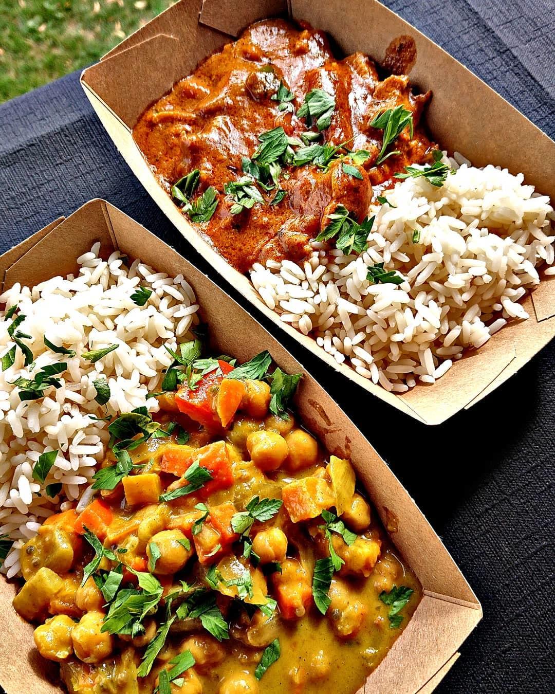 Zwei Currys mit Reis in Pappschalen — Kichererbsen-Curry und ein rotes Curry, frisch aus dem Truck